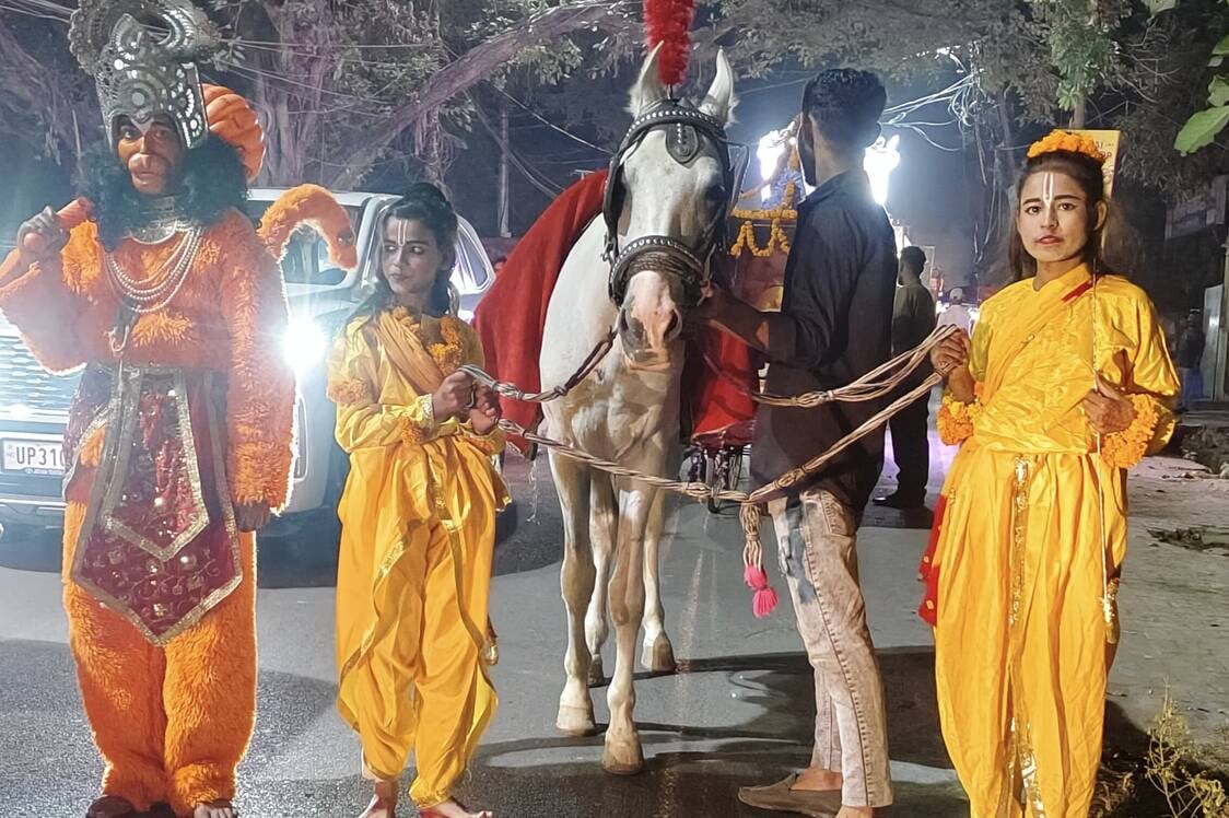 शोभायात्रा में लव-कुश और हनुमान की झांकी देखते लोग। स्रोत:आयोजक