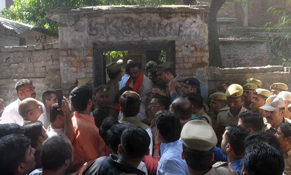 हत्या के आरोपी के घर में घुसे लोगों को निकालती पुलिस। हत्या के आरोपी के घर में घुसे लोगों को निकालती पुलिस।