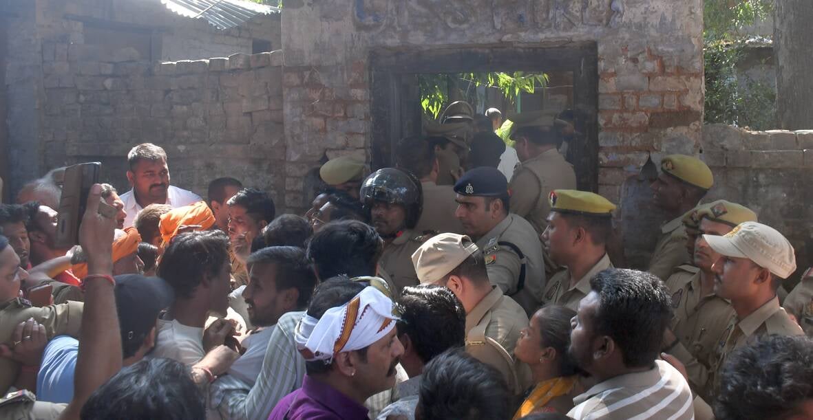 हत्या के आरोपी के घर में घुसे लोगों को निकालती पुलिस। हत्या के आरोपी के घर में घुसे लोगों को निकालती पुलिस।