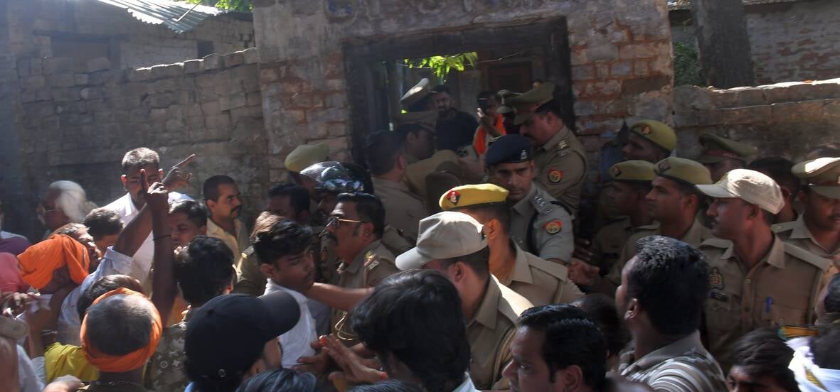 हत्या के आरोपी के घर में घुसे लोगों को निकालती पुलिस। हत्या के आरोपी के घर में घुसे लोगों को निकालती पुलिस।