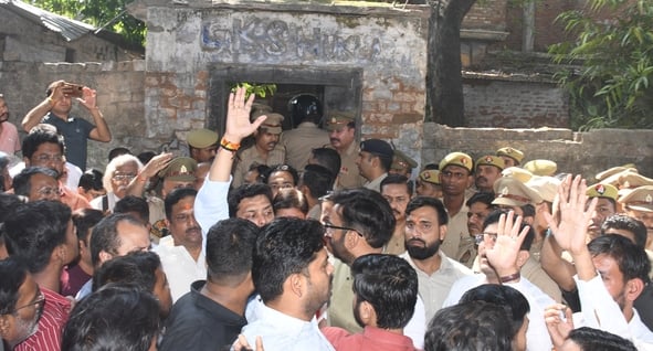 हत्या के आरोपी के घर में घुसे लोगों को निकालती पुलिस। हत्या के आरोपी के घर में घुसे लोगों को निकालती पुलिस।