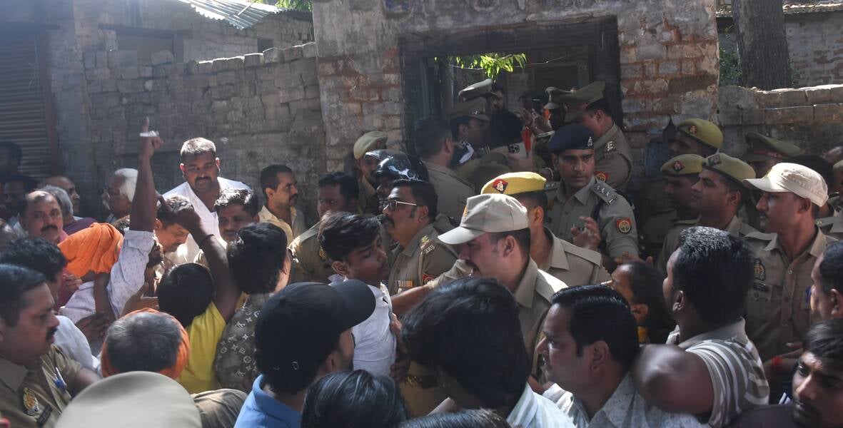 हत्या के आरोपी के घर में घुसे लोगों को निकालती पुलिस। हत्या के आरोपी के घर में घुसे लोगों को निकालती पुलिस।