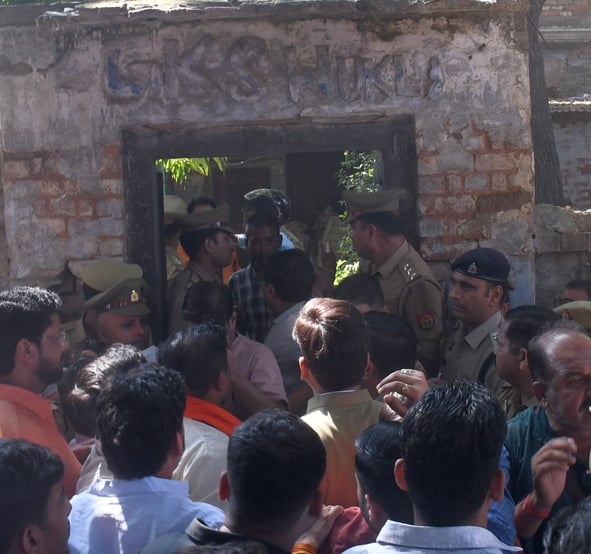 हत्या के आरोपी के घर में घुसे लोगों को निकालती पुलिस। हत्या के आरोपी के घर में घुसे लोगों को निकालती पुलिस।