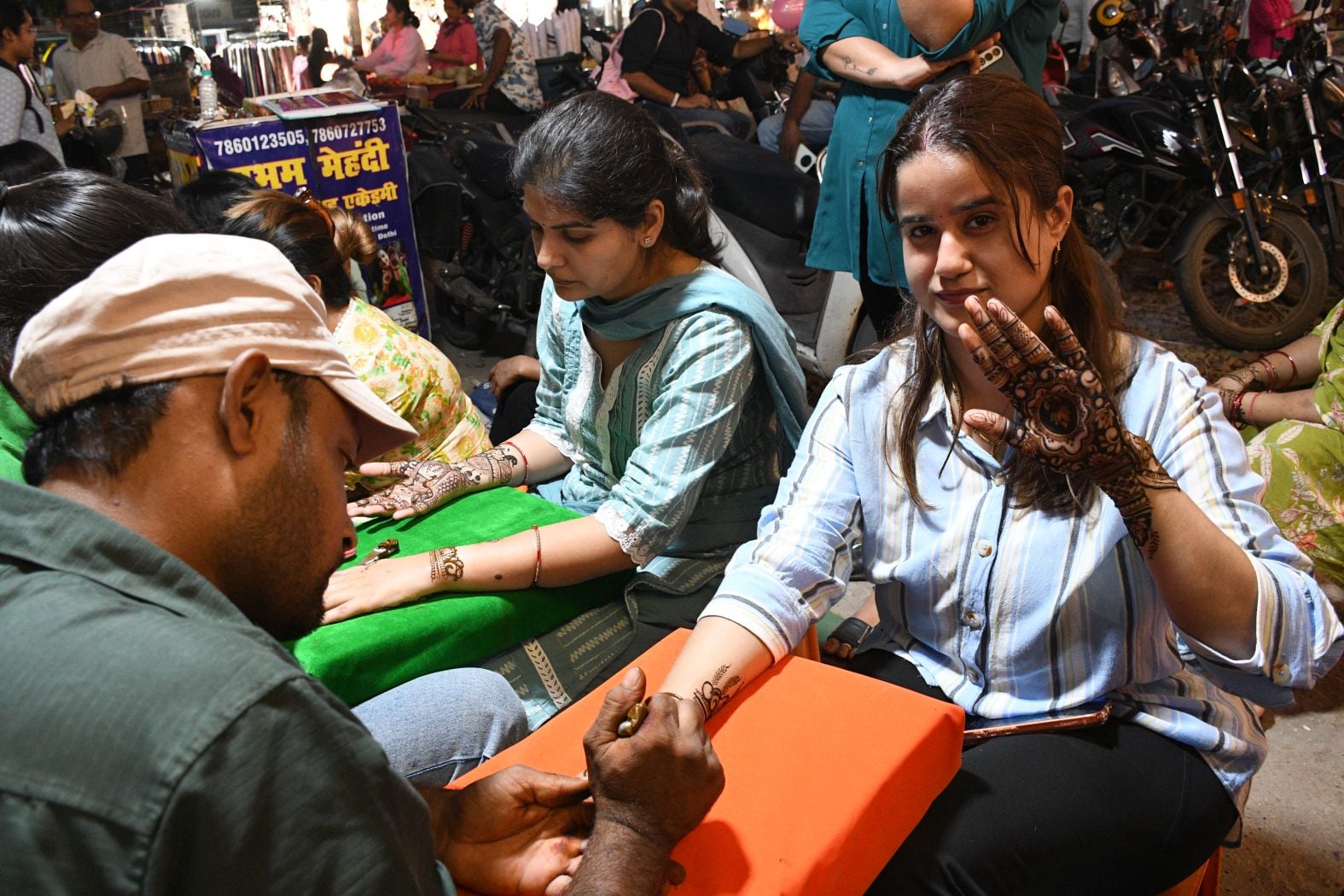 करवा चौथ पर खरीदारी करतीं व हाथ में मेहंदी लगवातीं महिलाएं करवा चौथ पर खरीदारी करतीं व हाथ में मेहंदी लगवातीं महिलाएं
