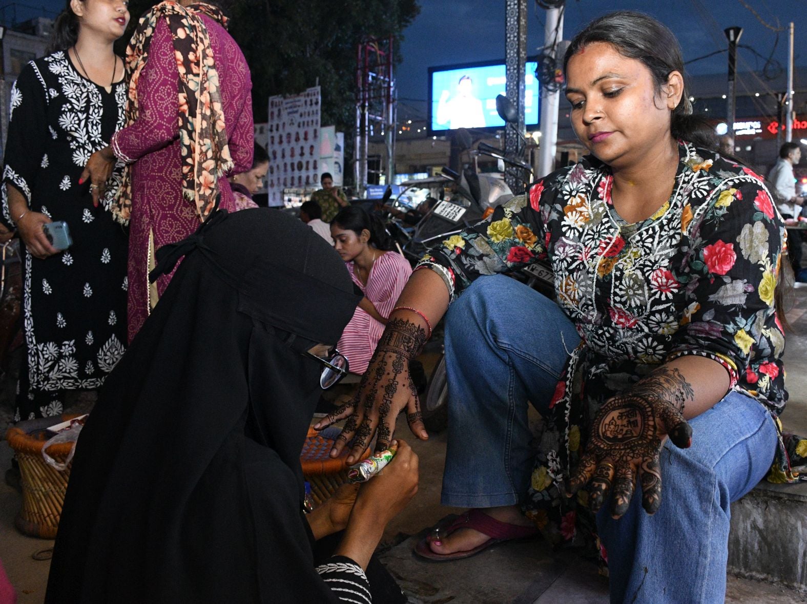 करवा चौथ पर खरीदारी करतीं व हाथ में मेहंदी लगवातीं महिलाएं करवा चौथ पर खरीदारी करतीं व हाथ में मेहंदी लगवातीं महिलाएं