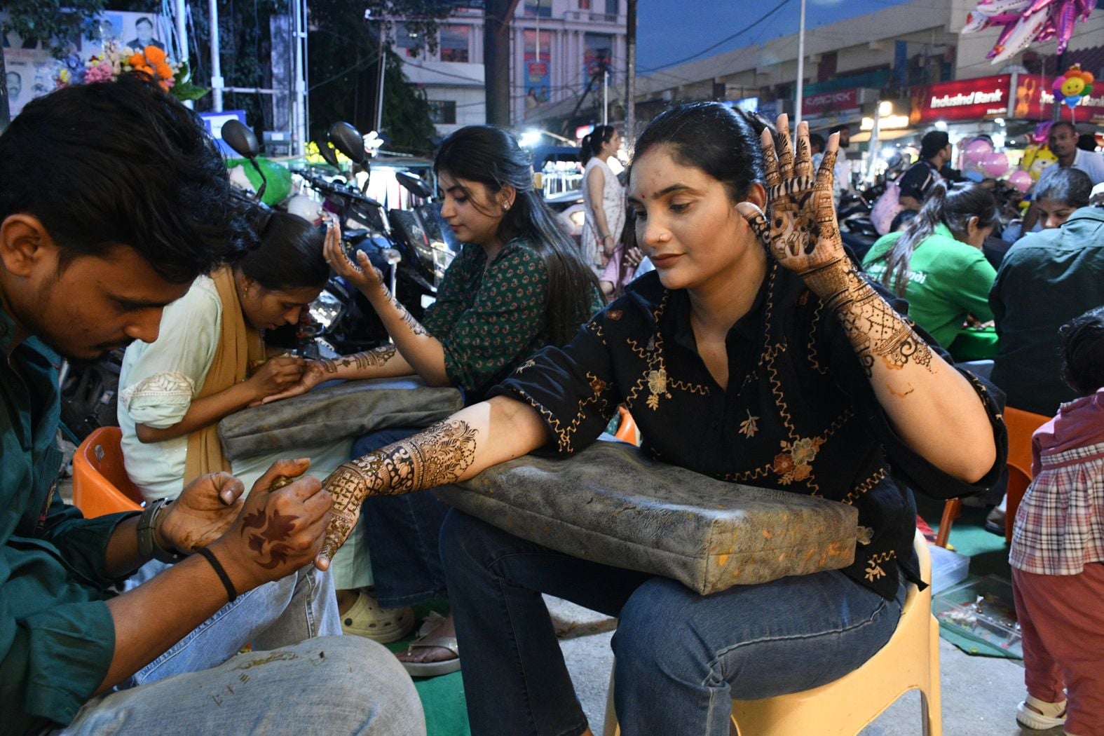 करवा चौथ पर खरीदारी करतीं व हाथ में मेहंदी लगवातीं महिलाएं करवा चौथ पर खरीदारी करतीं व हाथ में मेहंदी लगवातीं महिलाएं