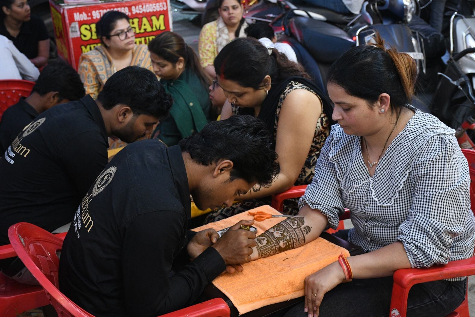 करवा चौथ पर खरीदारी करतीं व हाथ में मेहंदी लगवातीं महिलाएं करवा चौथ पर खरीदारी करतीं व हाथ में मेहंदी लगवातीं महिलाएं