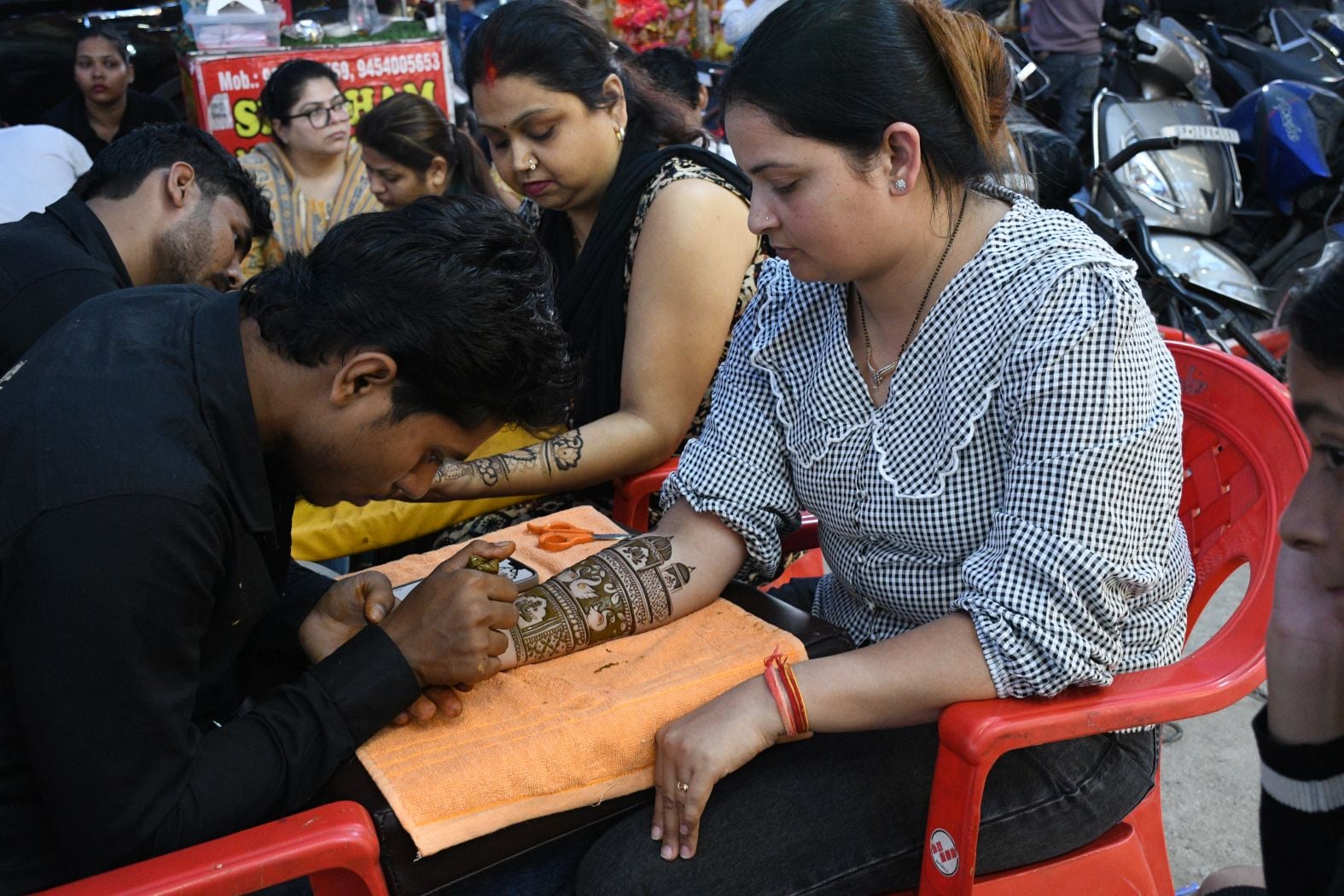 करवा चौथ पर खरीदारी करतीं व हाथ में मेहंदी लगवातीं महिलाएं करवा चौथ पर खरीदारी करतीं व हाथ में मेहंदी लगवातीं महिलाएं