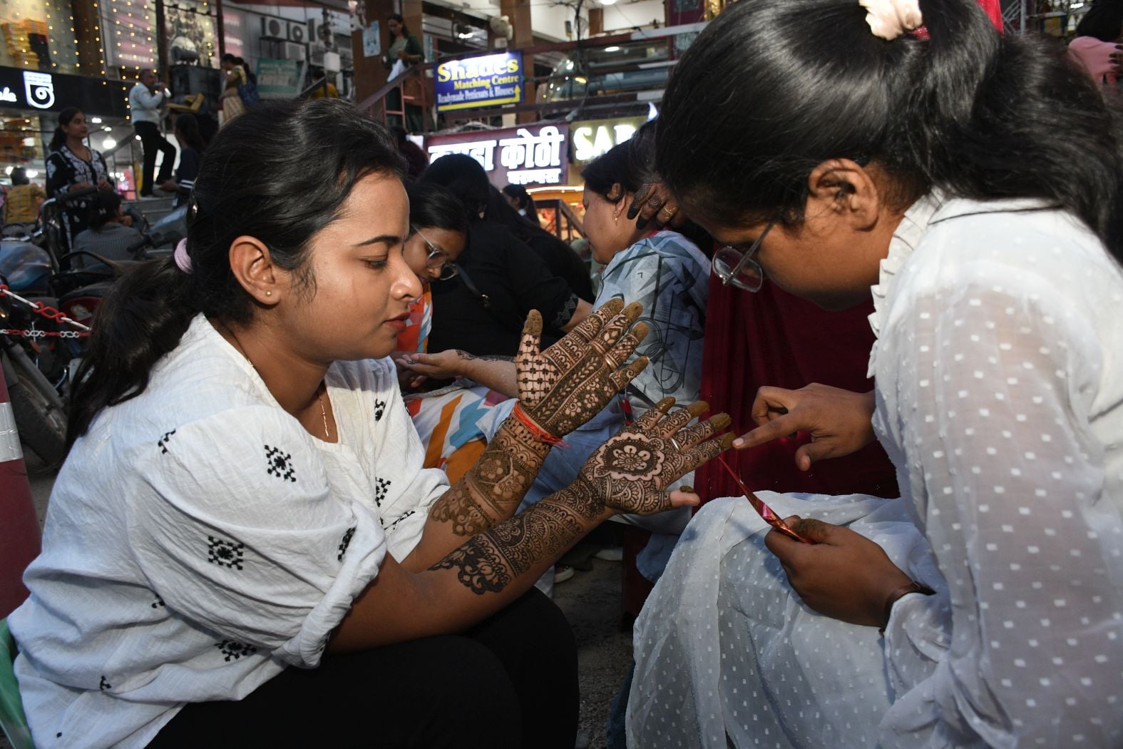 करवा चौथ पर खरीदारी करतीं व हाथ में मेहंदी लगवातीं महिलाएं करवा चौथ पर खरीदारी करतीं व हाथ में मेहंदी लगवातीं महिलाएं