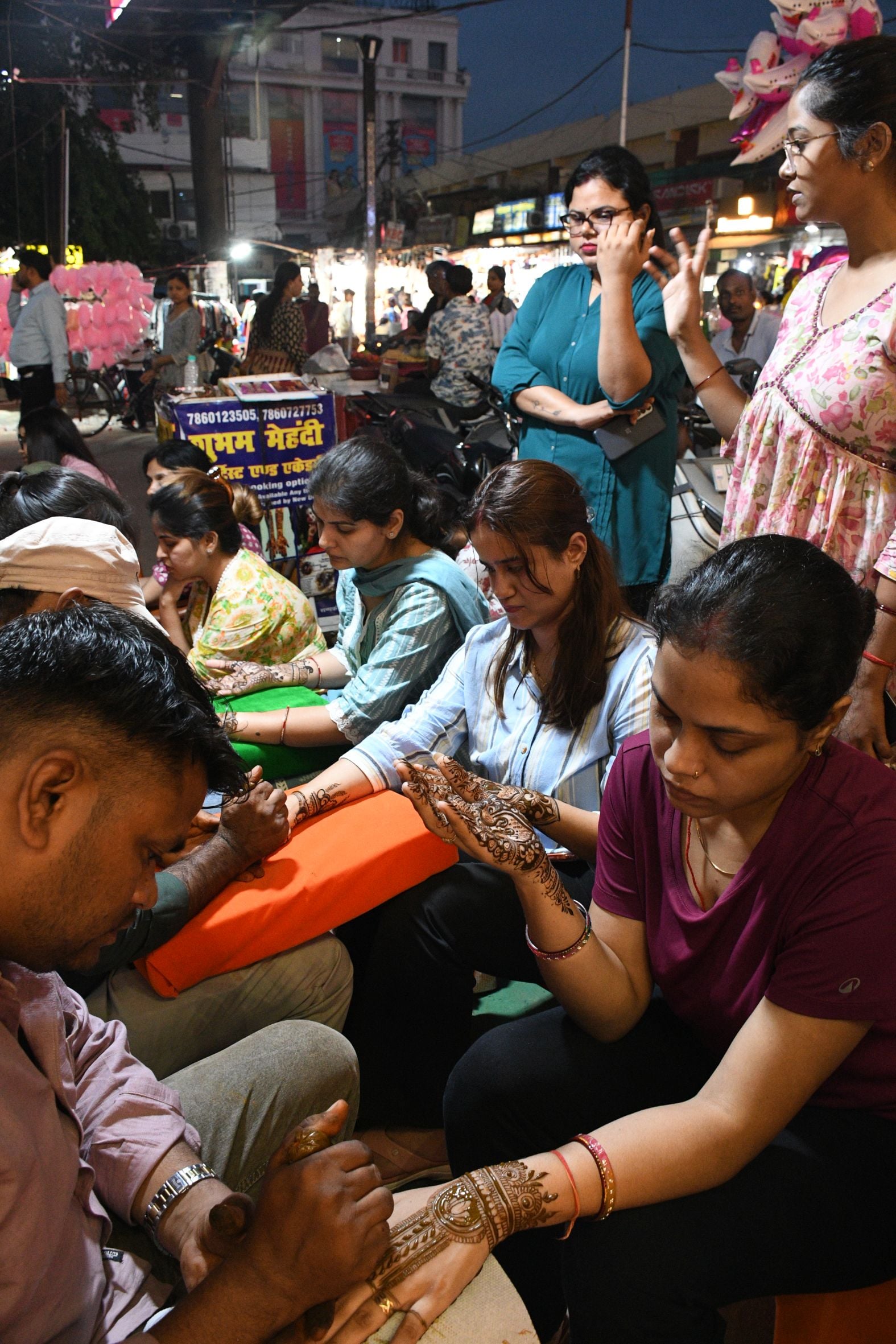 करवा चौथ पर खरीदारी करतीं व हाथ में मेहंदी लगवातीं महिलाएं करवा चौथ पर खरीदारी करतीं व हाथ में मेहंदी लगवातीं महिलाएं
